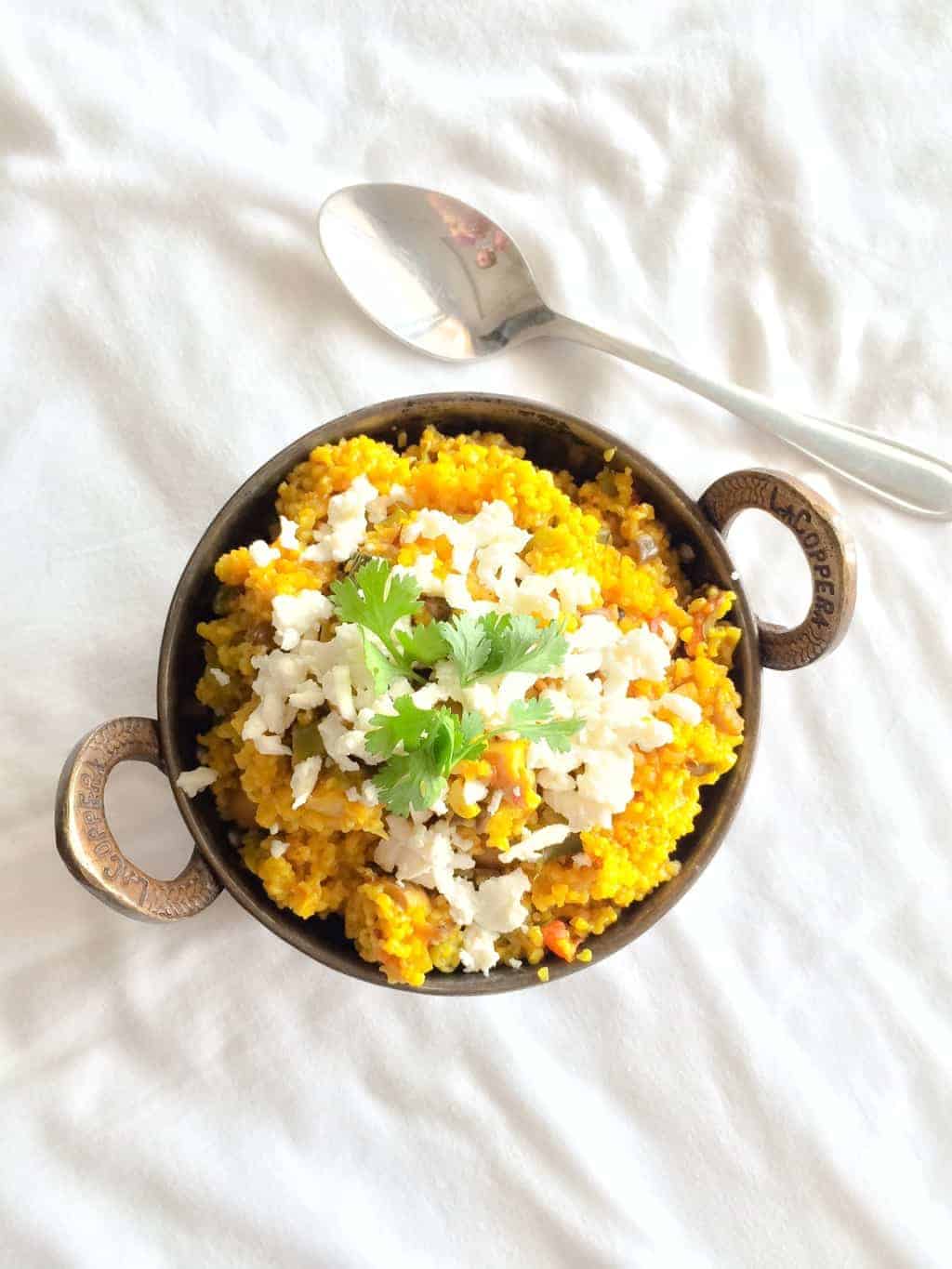 bulgur wheat daliya served in a copper bowl placed on a white background
