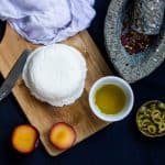 A picture of Homemade Cream Cheese on a wooden board along with Olive oil and Plum.