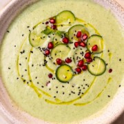 cold cucumber soup garnished with cucumber slices, pomegranate and nigella seeds ready to be served