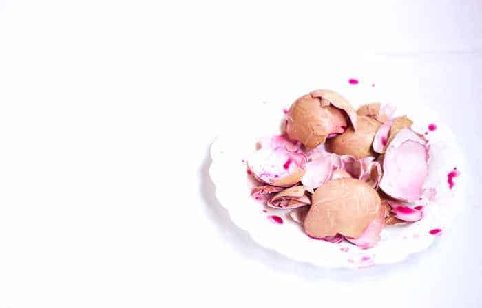 dyed egg shells in a white plate