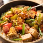 Sweet Chili Tofu Stir Fry served over rice in a bowl.