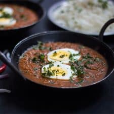 The egg curry garnished with coriander and served with rice.