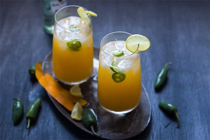 tall mango jalapeno fizzy cocktail served with ice and slices of lemon