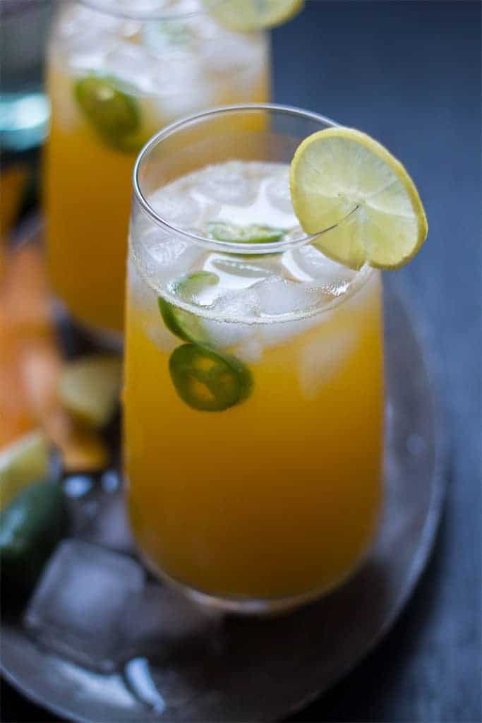 tall mango jalapeno fizzy cocktail served with ice and slices of lemon