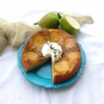 A slice stolen from the Upside Down Pear Cake served with whipped cream.