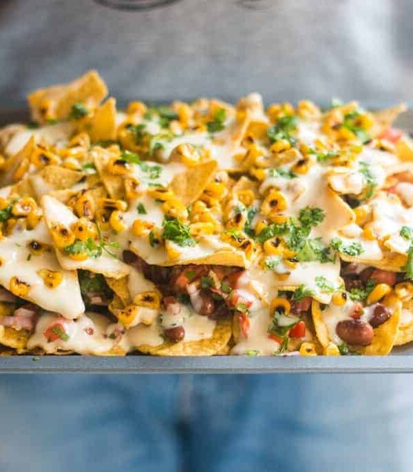 The loaded nachos being served in a tray.