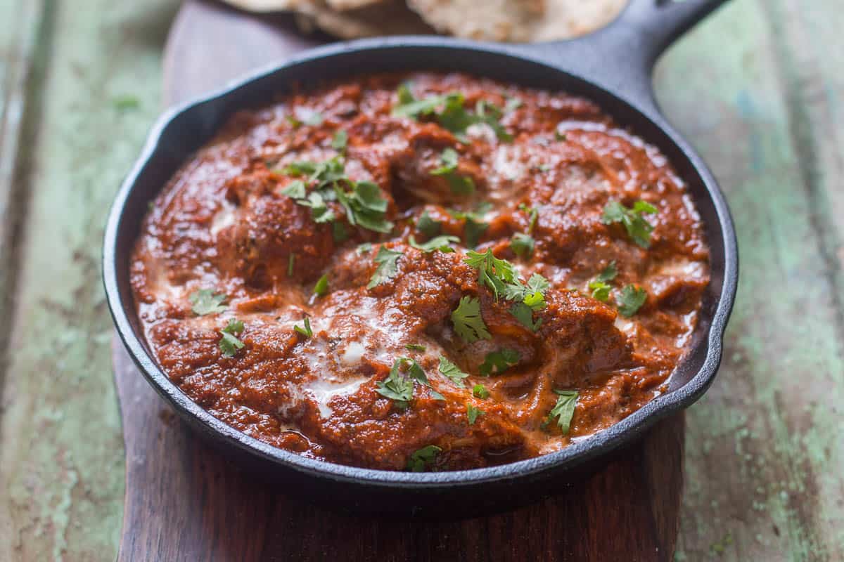 The healthier version of Chicken Tikka Masala garnished with coriander in a pan.