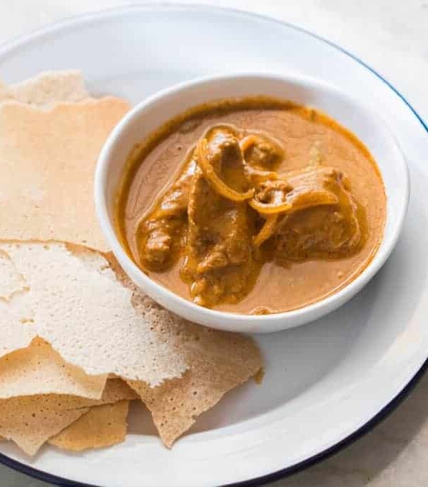 Chicken Kori Rotti served in a white plate.