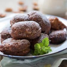The fritters served in a white plate and garnished with mint leaves.