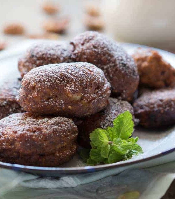 The fritters served in a white plate and garnished with mint leaves.