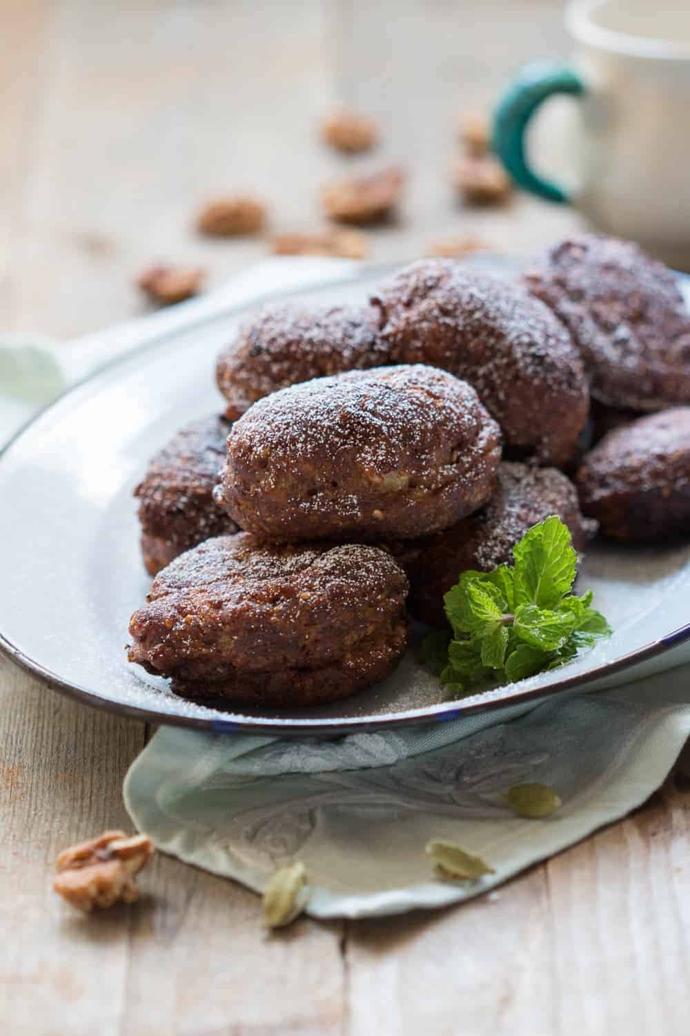 the fritters served in a white plate, garnished with mint leaves
