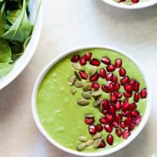 The smoothie bowl topped with pomegranate and pumpkin seeds.