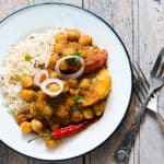 A picture of the curry plated with rice and onions.