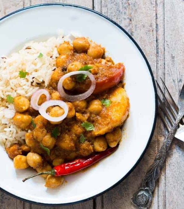 A picture of the curry plated with rice and onions.