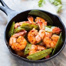 The chilli garlic prawns in a black pan.