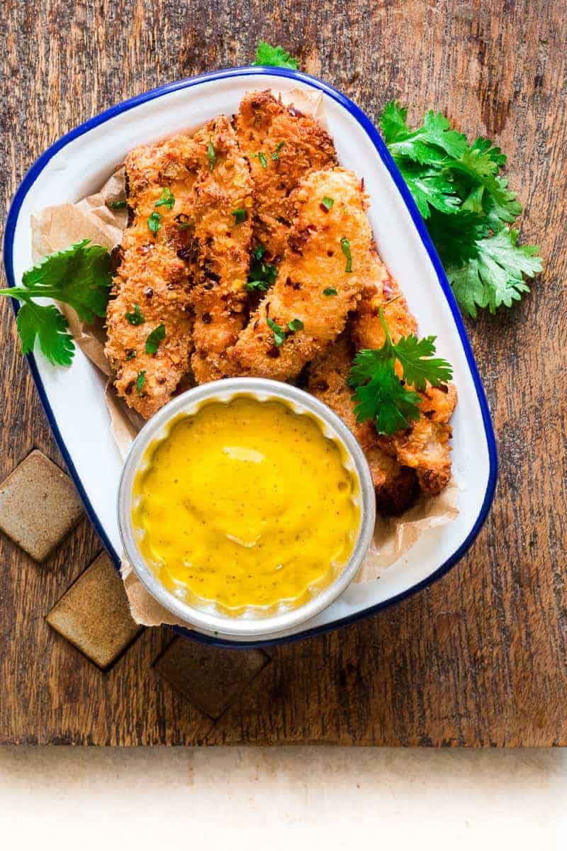 Baked Coconut Chicken Tenders with Mango Mustard Sauce Easy recipe for super crunchy baked coconut crusted chicken tenders which are going to be a favourite at every party with kids and adults alike! Gluten free too.