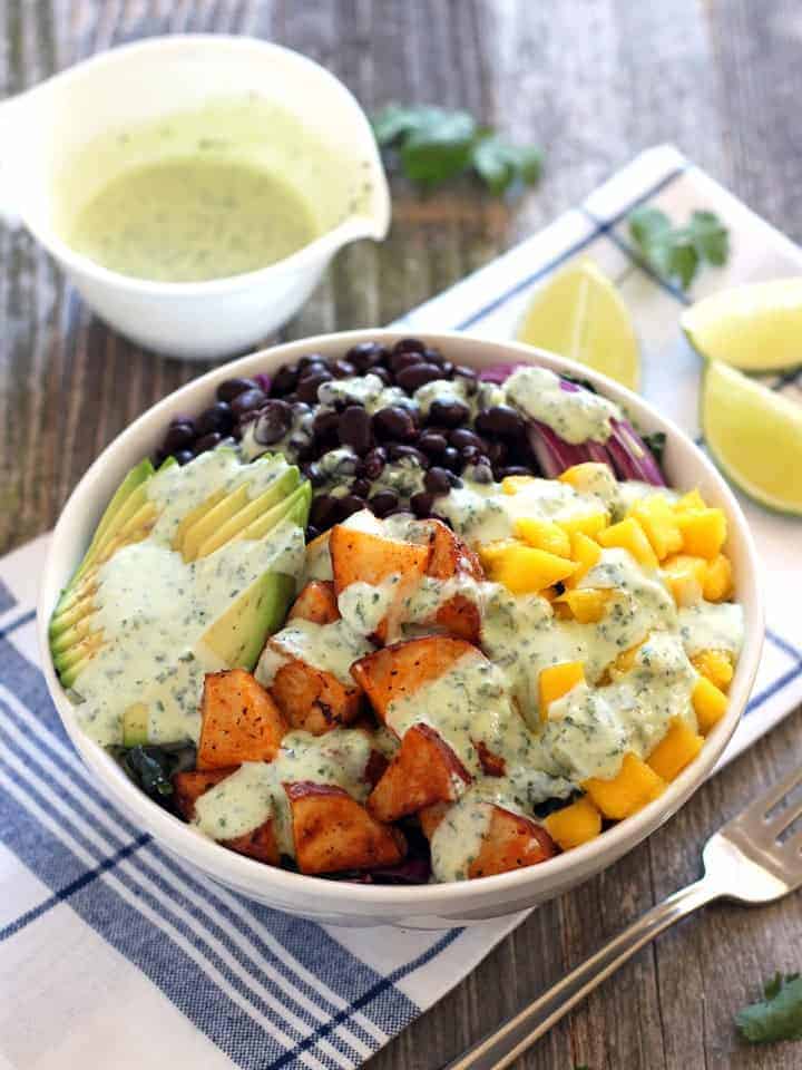 A collection of 13 insanely delicious savoury mango recipes that are sure to blow your mind if you've always had mangoes in sweet dishes. These recipes combine the juicy sweetness of mangoes with savoury ingredients to create a dish that's truly stellar and unforgettable! #spring #mango #recipes #easter #summer #fruit Mango sriracha potato veggie bowls with dressing poured on top and some dressing kept on the side