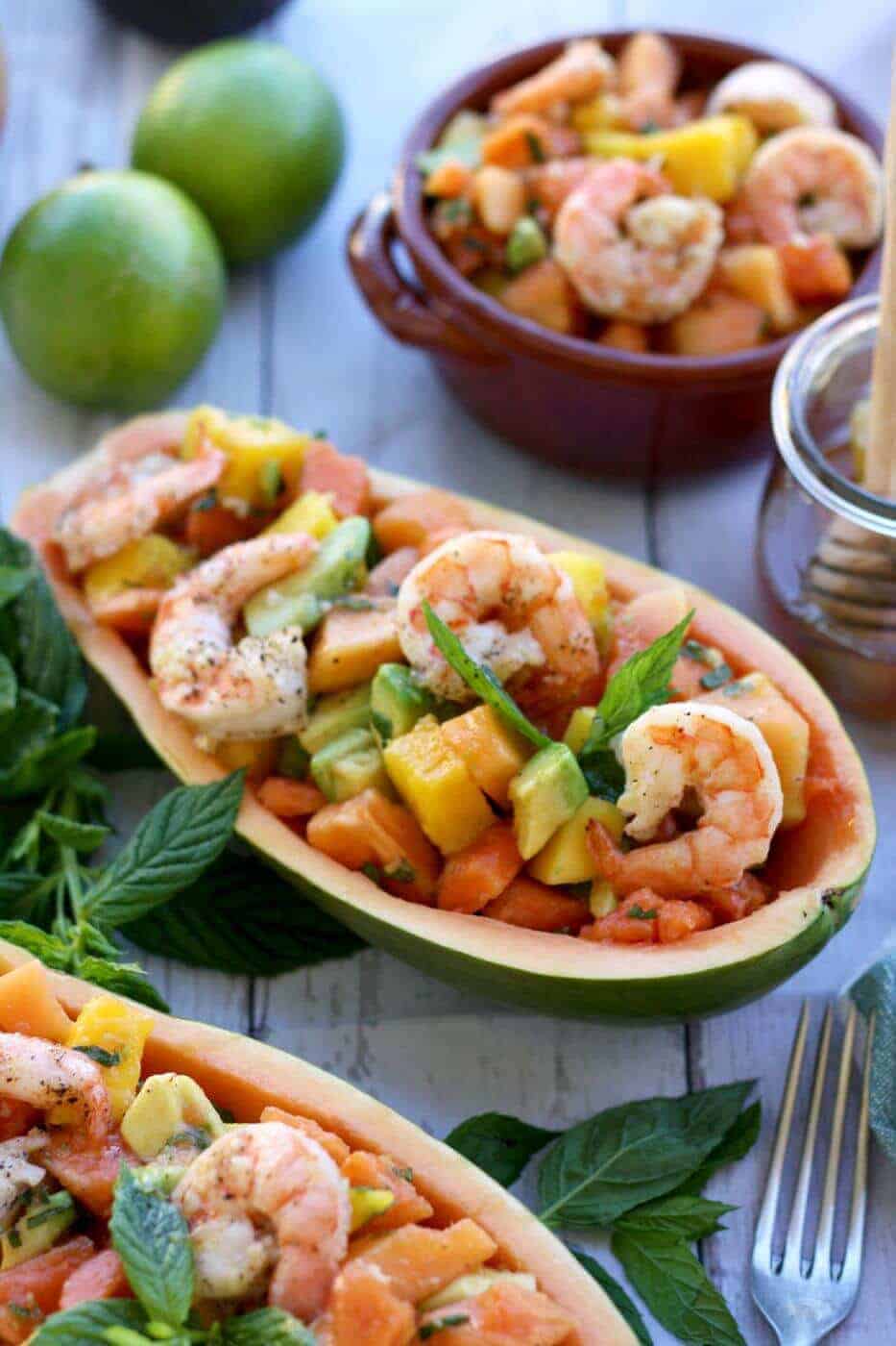A collection of 13 insanely delicious savoury mango recipes that are sure to blow your mind if you've always had mangoes in sweet dishes. These recipes combine the juicy sweetness of mangoes with savoury ingredients to create a dish that's truly stellar and unforgettable! #spring #mango #recipes #easter #summer #fruit Papaya prawn mango salad served in papaya boats