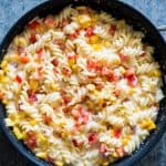 Lighter Creamier Corn Pepper Fusilli Alfredo in a black pan.