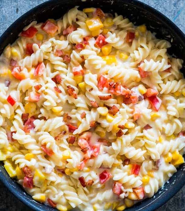 Lighter Creamier Corn Pepper Fusilli Alfredo in a black pan.