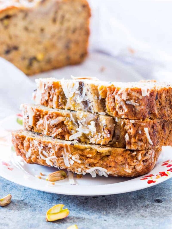 Quick Coconut Pistachio Banana Bread sliced and served on a white plate.