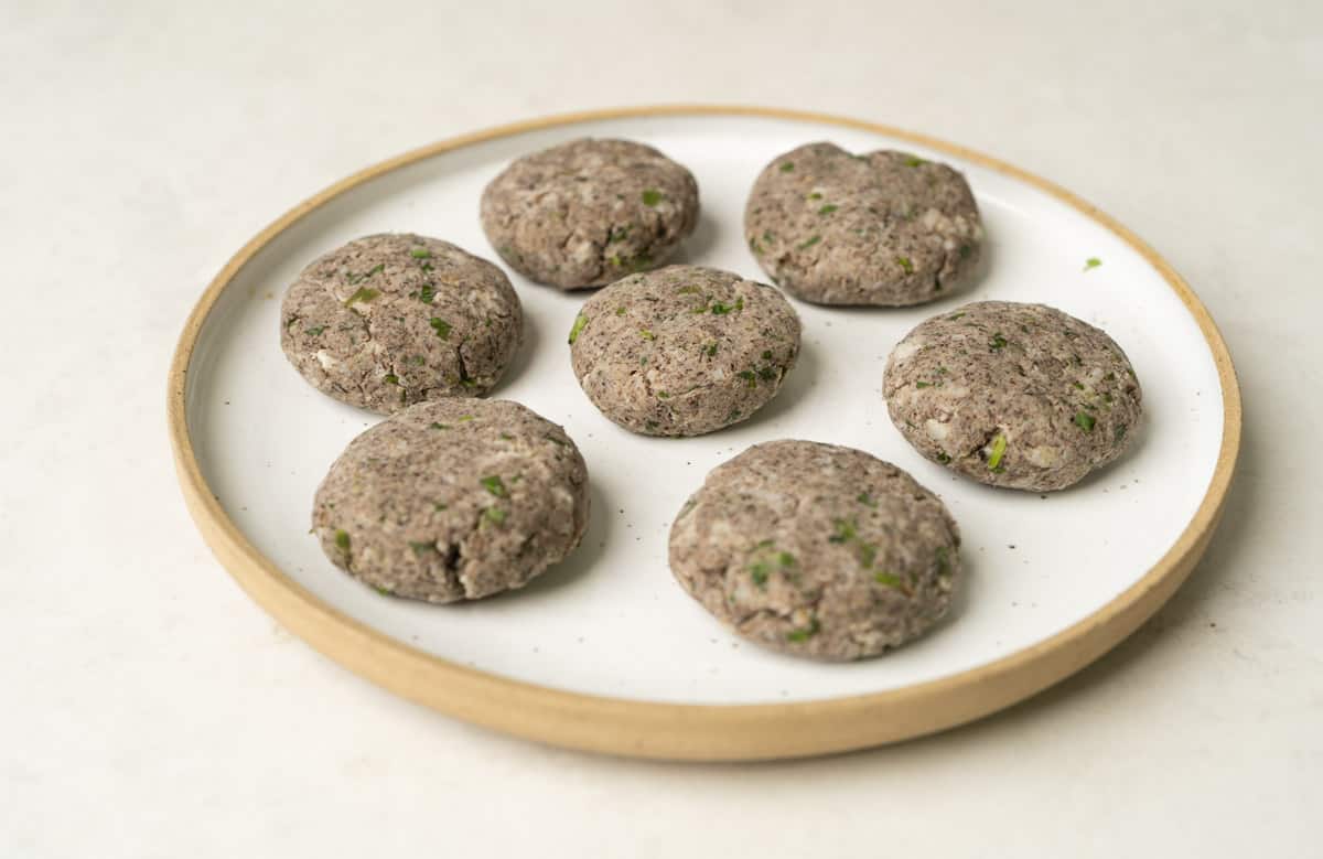 raw banana tikki or kachhe kele ke kebab shaped and placed on a white plate