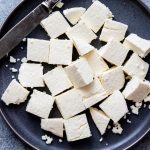 Cubes of paneer on a dark plate