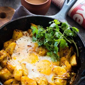 Spiced Indian Potatoes and eggs are cooked in a skillet for a hearty and easy holiday morning breakfast recipe. Perfect for a crowd, kid friendly and gluten free.
