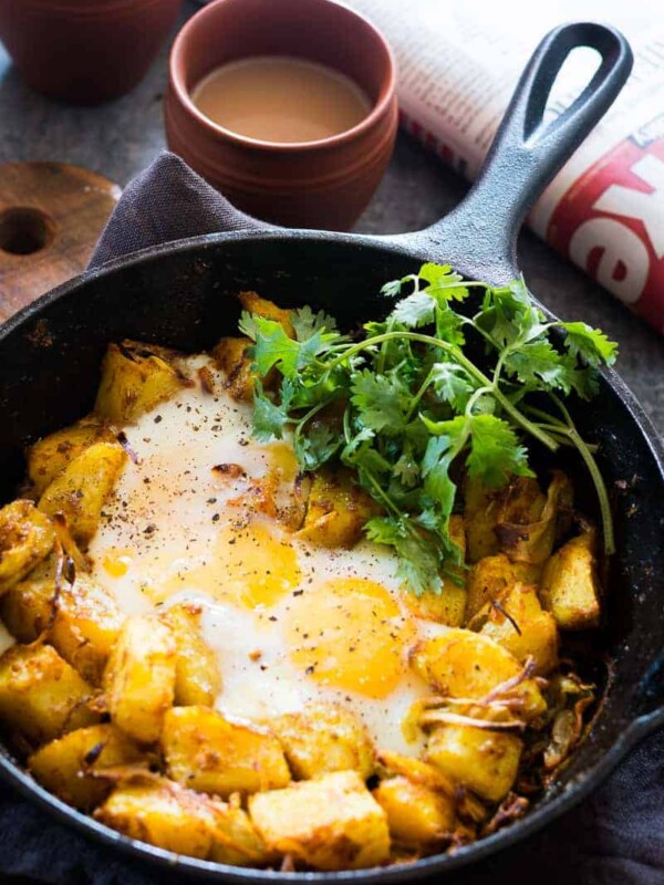 Spiced Indian Potatoes and eggs are cooked in a skillet for a hearty and easy holiday morning breakfast recipe. Perfect for a crowd, kid friendly and gluten free.
