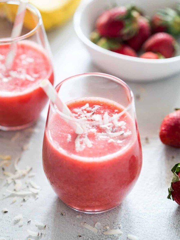 Strawberry Banana Coconut Smoothie garnished with grated coconut and served in a glass with a straw to kick in those tropical vibes!