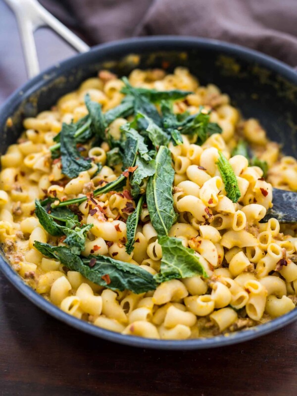 Creamy Pumpkin Sausage Mac and Cheese garnished with kale.