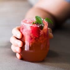 Mint Strawberry Moscow Mule Cocktail garnished with mint, salt and served in a glass.
