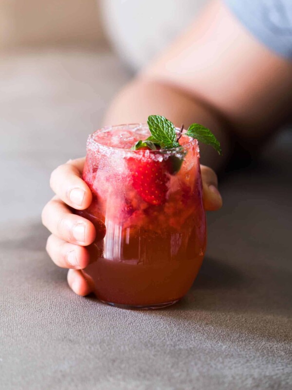 Mint Strawberry Moscow Mule Cocktail garnished with mint, salt and served in a glass.