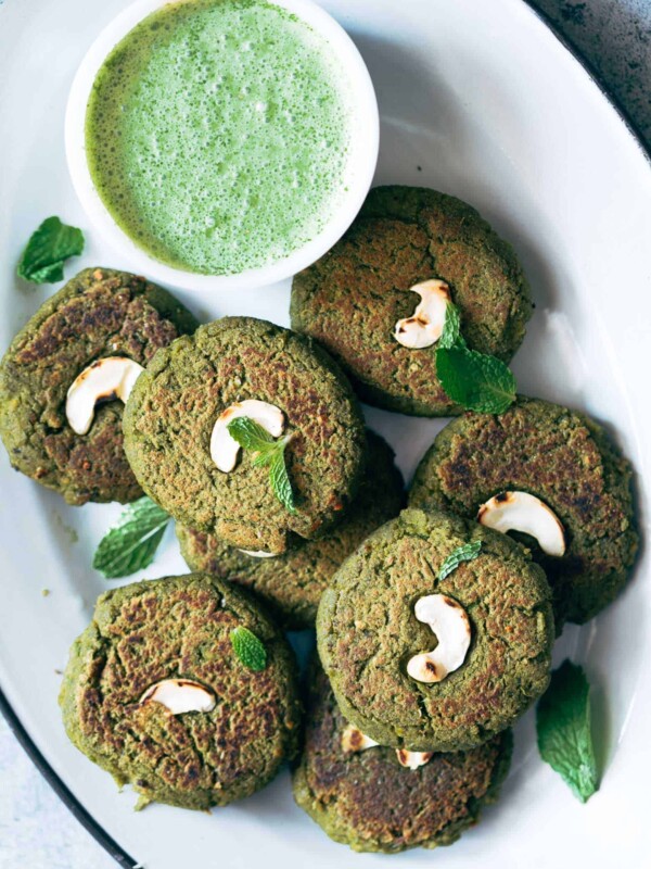 Soya Hara Bhara Kebab served with green chutney on a white plate.