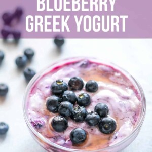 Blueberry greek yogurt served in a bowl with blueberries and honey drizzled on top