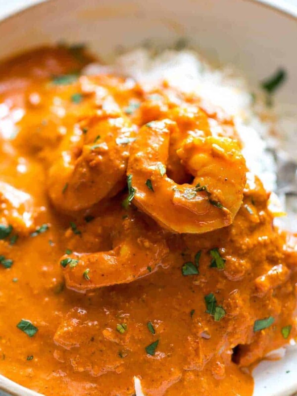 Rice topped with Goan prawn curry and served in a white bowl.