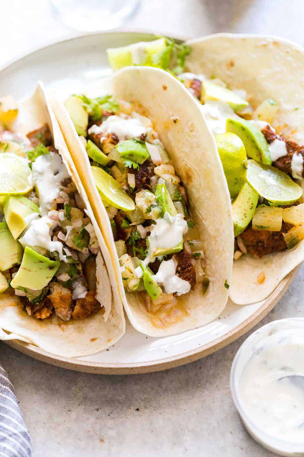 Tilapia Fish Tacos with Pineapple Salsa served on a white plate with a side of Big Banyan's sauvignon blanc.