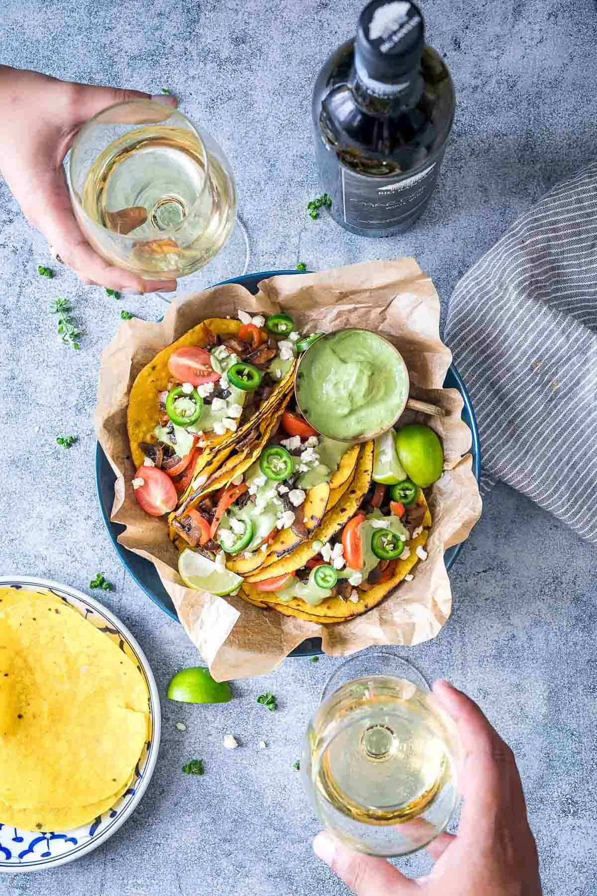 Vegetarian Portobello Mushroom Fajita Tacos served with avocado cilantro sauce on the side and being enjoyed with Big Banyan's Chardonnay white wine.