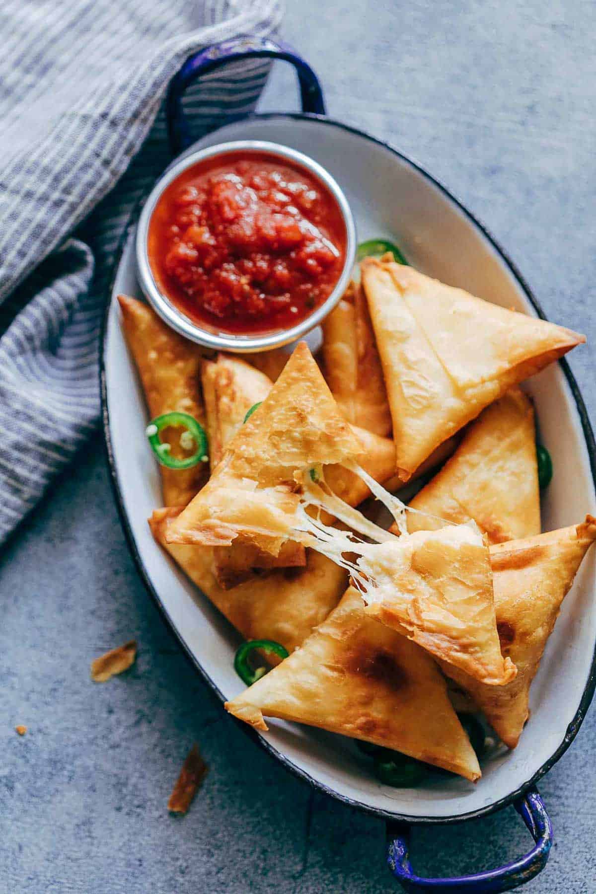 Super cheesy jalapeno three cheese samosa are sure to become a favourite because who can resist gooey stringy cheese stuffed in crispy samosa wrappers! These vegetarian samosas have a filling of mozzarella, cream cheese, smoked cheddar and jalapenos and folding them is really easy too. 