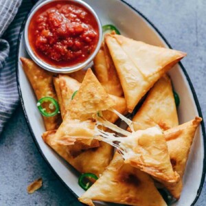 Super cheesy jalapeno three cheese samosa are sure to become a favourite because who can resist gooey stringy cheese stuffed in crispy samosa wrappers! These vegetarian samosas have a filling of mozzarella, cream cheese, smoked cheddar and jalapenos and folding them is really easy too.ย
