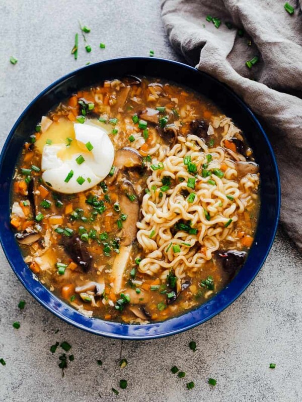 A bowl of chinese hot and sour soup with ramen served with a soft boiled egg and green onions ready to eat!