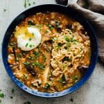 A bowl of chinese hot and sour soup with ramen served with a soft boiled egg and green onions ready to eat!