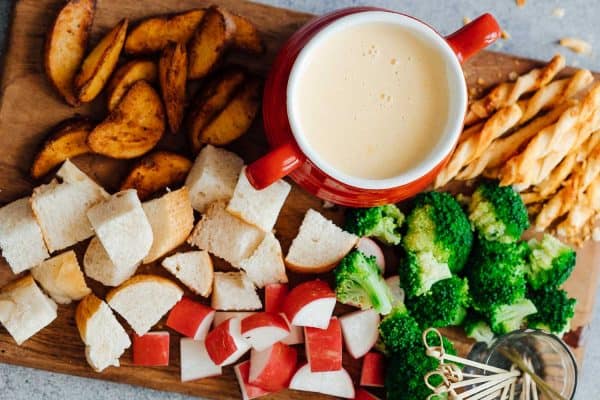 Easy cheese fondue recipe with white wine picture with fondue dippers such as bread, broccoli, wedges, radishes, bread sticks etc.