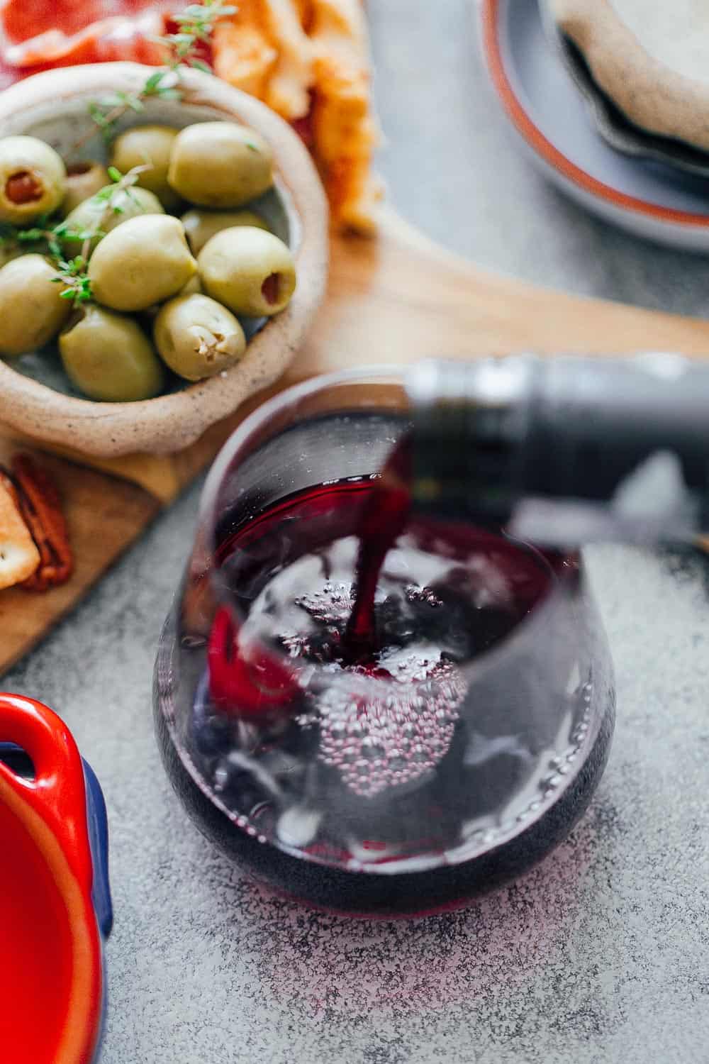 Pouring wine for the ultimate wine and cheese board on a budget