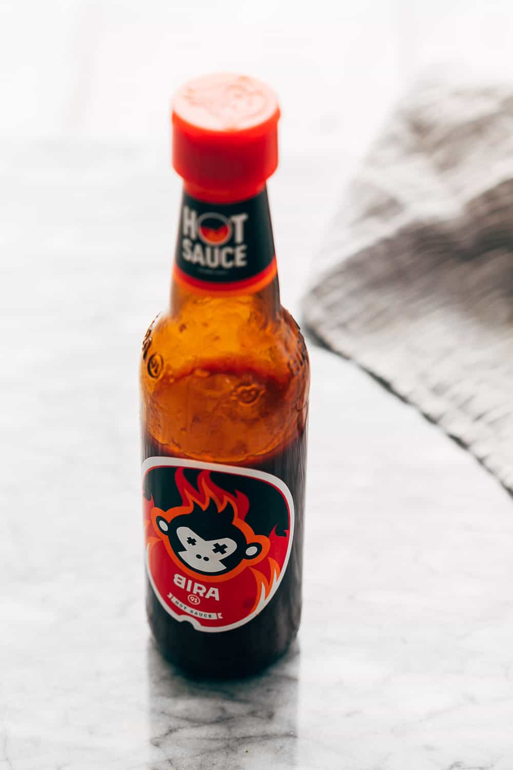 KOREAN POPCORN CHICKEN is sticky, spicy, tangy and crunchy. Inspired by the hyper-famous Korean street snack, Dakgangjeong, boneless chicken is deep fried and tossed in a sweet, sour and spicy sauce that makes every bite super addictive. #chicken #appetizer #party #snack #recipe Picture of Bira's hot sauce on the countertop