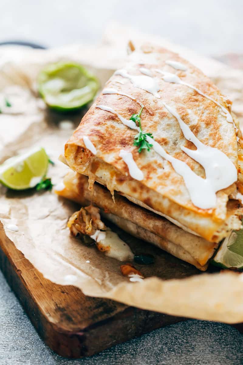 Closeup of chicken fajita quesadillas with sour cream drizzled on top