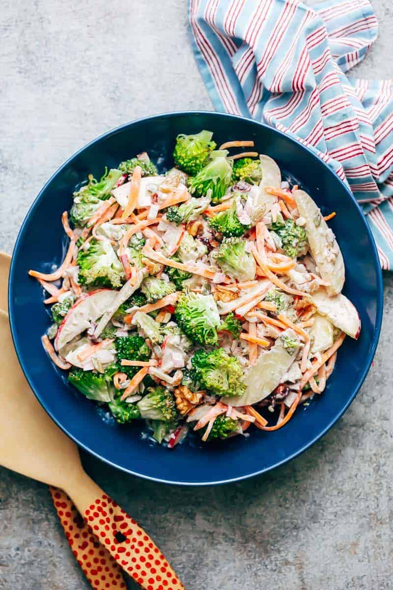 Creamy apple broccoli walnut salad served in a blue bowl