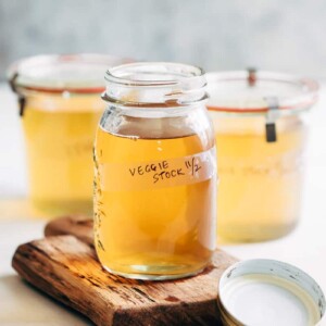 Homemade vegetable stock strained into a canning jar