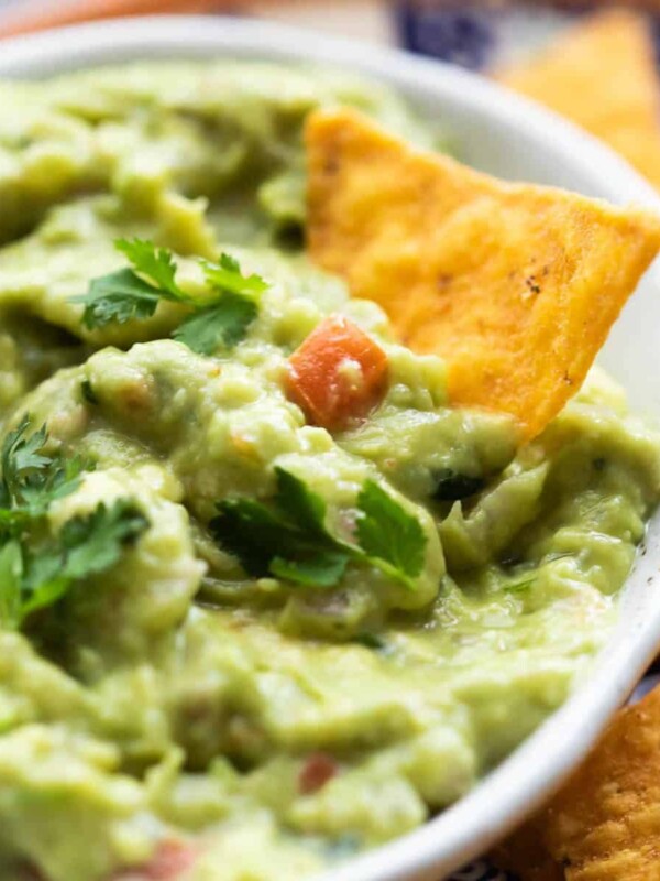 Close up of homemade guacamole with a chip in the bowl.