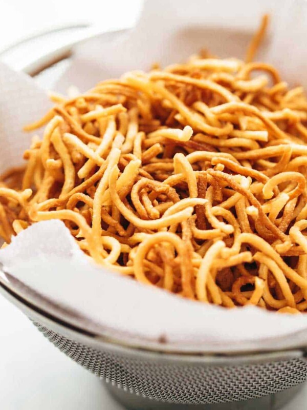 Fried noodles draining on paper towels in a colander to get rid of any excess oil
